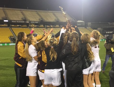 Walsh Jesuit women's soccer team raise the state championship trophy.