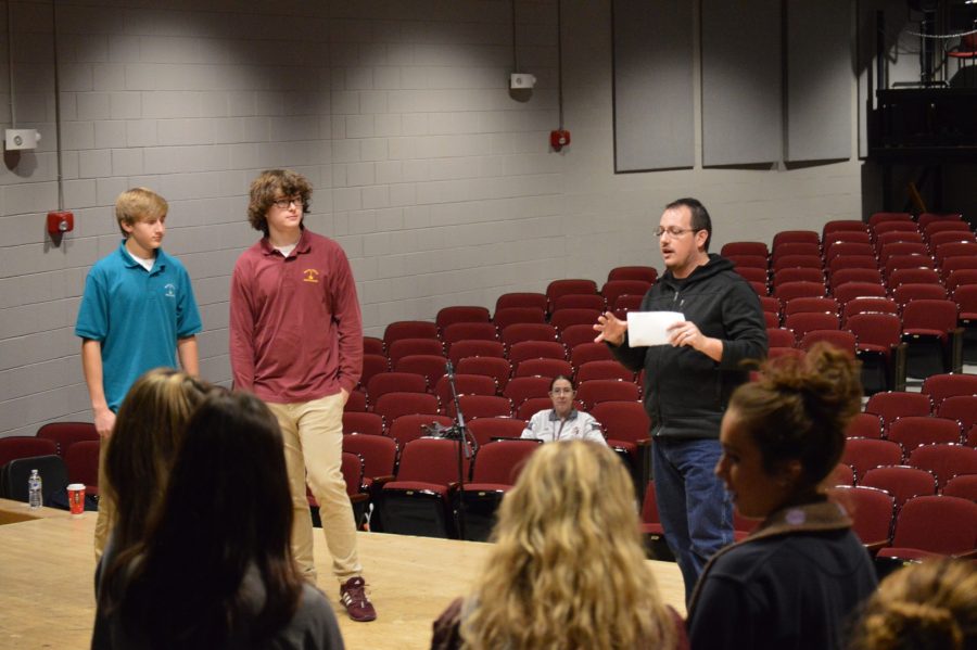 Dane Leasure is helping students learn their lines before they perform in front of their classmates. Students learn is that it is considered bad luck to say Macbeth while working on the play. 