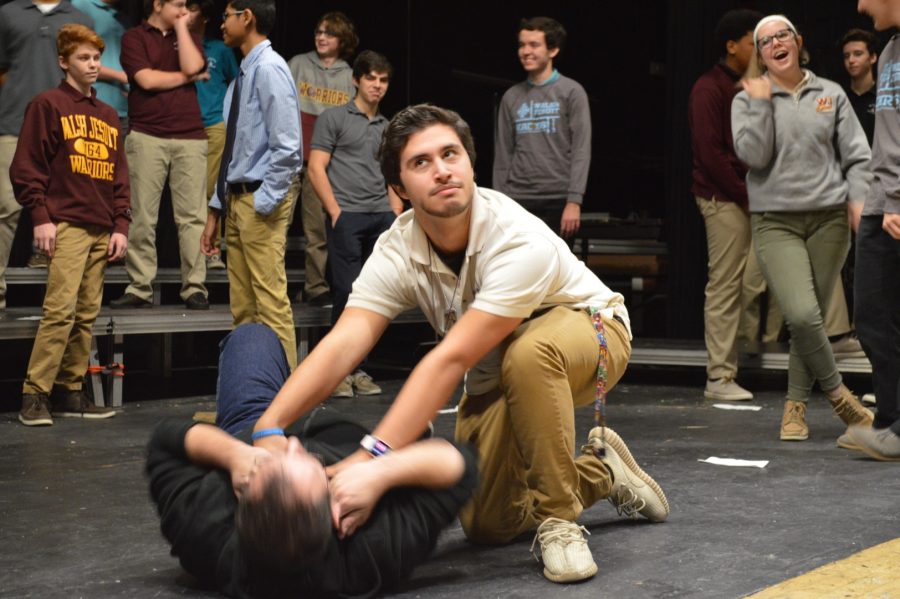 Junior Virgil Glorioso is practicing his combat scene as he takes down Dane Leasure. He is showing the rest of his classmates how to act while making it look realistic. 