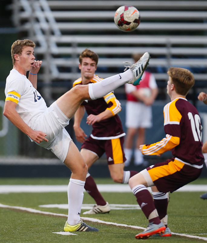 Archbishop Hobans Mikey Burrington kicks the ball back away from Walsh Jesuits Sam Thompson (right) in the first half Tuesday at Archbishop Hobans Dowed Field. (Leah Klafczynski/Akron Beacon Journal)
