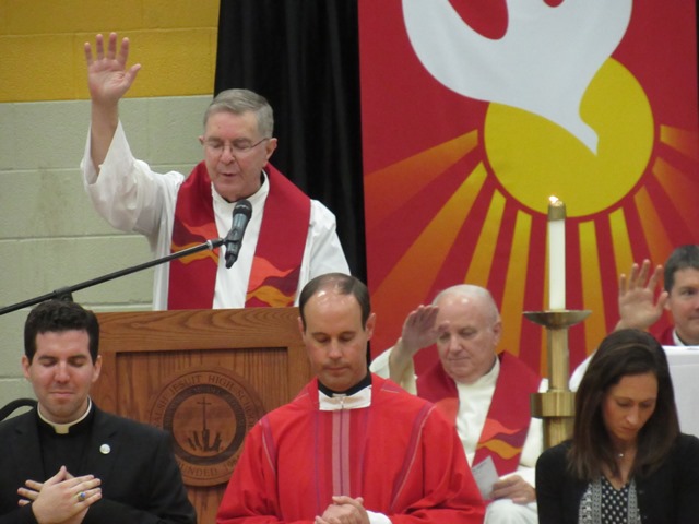 As the Walsh Jesuit family raises their hands in blessing, Fr. Don Petkash, vice-president for Ignatian Identity, reads a benediction for the new faculty and staff. 