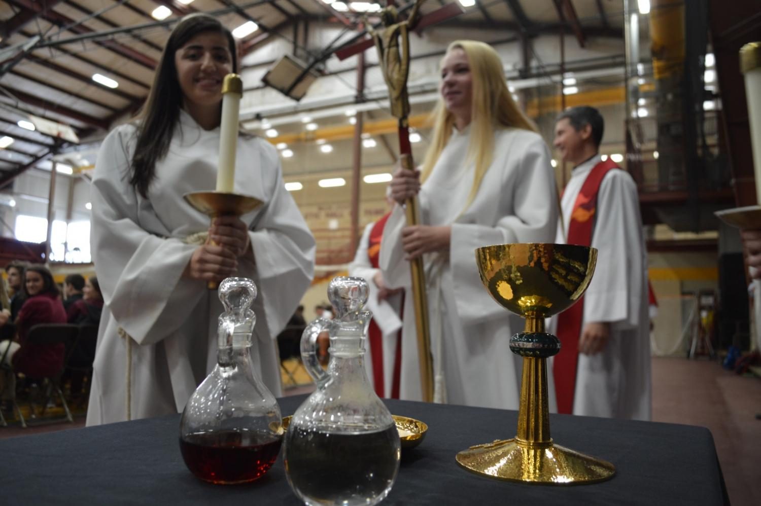Juniors Emily Backo and Jessie Brown prepare to serve as Walsh Jesuit celebrated the centuries-old Jesuit tradition at the beginning of the school year, the Mass of the Holy Spirit. 
