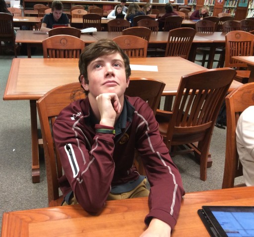 Luke Keirn. 21, ponders the essay composition process in the library before writing for his English class. 
