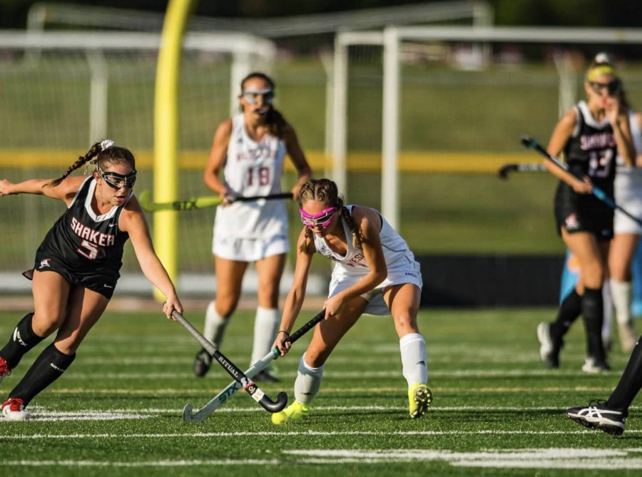 Junior Macy Buck  contends with a Shaker Heights rival as she passes the ball to a teammate.  