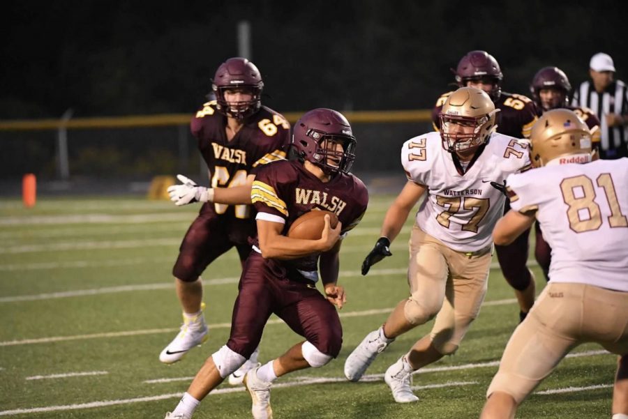 Senior quarterback Cam Mayes runs the ball for the Warriors against Bishop Watterson. 