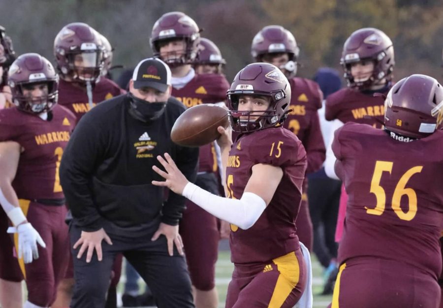 A masked Coach Turner works with junior Matt Natale this year as all coaches and athletic personnel find safe ways to adapt.  