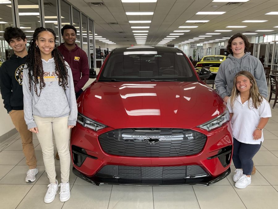 Posing with the raffle prize, these students raced for the chance to check out this 2022 Rapid Red Mustang Mach-E AWD. 