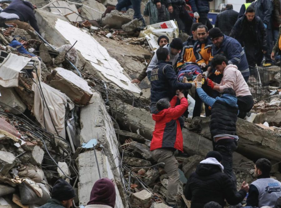 People+and+emergency+rescue+crews+remove+someone+on+a+stretcher+from+one+of+hundreds+of+collapsed+buildings.+